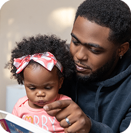 Father reading a book to his daughter